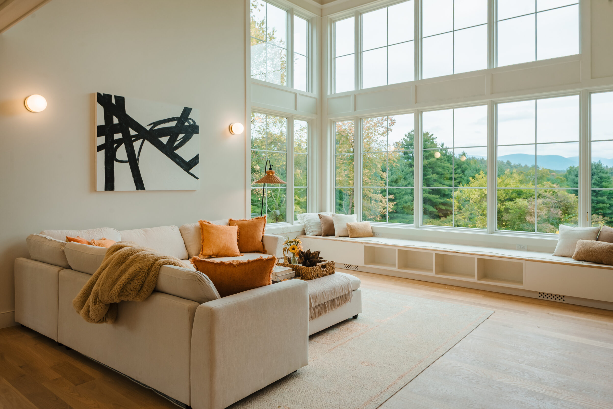 Hemlock House — double-height great room with a wall of divided-light windows facing the mountains